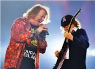  ?? MARK ALLAN/INVISION/THE ASSOCIATED PRESS ?? Instead of lamenting the loss of vocalist Brian Johnson, himself a replacemen­t for deceased frontman Bon Scott, AC/DC hired Guns N’ Roses frontman Axl Rose, seen with Angus Young at a June show in London, England.