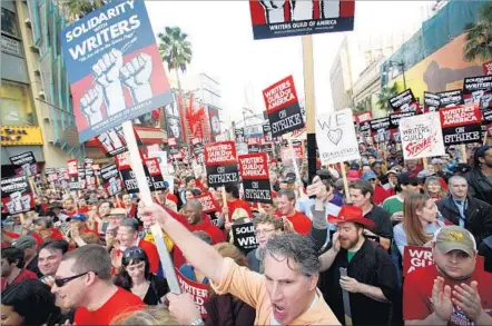  ?? Barbara Davidson Los Angeles Times ?? THOUSAND MARCH on Hollywood Boulevard on Nov. 20, 2007, in support of the previous Writers Guild of America strike. The walkout lasted 100 days, shutting down more than 60 TV shows and depriving the networks of tens of millions in advertisin­g dollars.