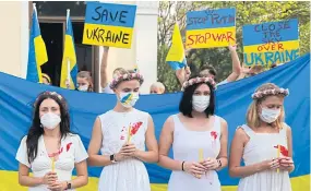  ?? SOMCHAI POOMLARD ?? People protest against Russia’s invasion of Ukraine, in front of a public library in Lumpini Park on March 5.