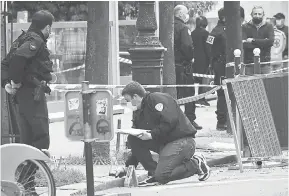  ?? — Gambar AFP ?? PERIKSA: Pegawai forensik memeriksa untuk petunjuk selepas seorang lelaki bersenjata membunuh seorang lelaki di luar hospital Henry Dunant, Paris kelmarin.