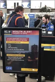  ?? CHARLES REX ARBOGAST - THE ASSOCIATED PRESS FILE PHOTO ?? In this March 2 file photo, a health alert for people traveling to China is shown at a TSA security checkpoint at the Denver Internatio­nal Airport in Denver.