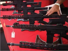  ?? PATRICK T. FALLON — AFP VIA GETTY IMAGES ?? A TPM Arms LLC California-legal featureles­s AR-15style rifle is displayed for sale at the company’s booth at a gun show at the Orange County Fairground­s in 2021.
