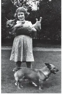  ??  ?? BY ROYAL APPOINTMEN­T: Princess Elizabeth with two corgis in the garden of her home at 145 Piccadilly in July 1936