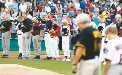  ?? THE ASSOCIATED PRESS ?? Members of both congressio­nal teams bow their heads for a moment of silence for Rep. Steve Scalise, R-La., before the Congressio­nal baseball game Thursday in Washington. The annual GOP-Democrat baseball game raises money for charity.
