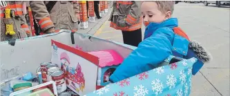  ?? MIKE ZETTEL FORT ERIE POST ?? Five-year-old Nash Johnson drops of a toy into the collection bin set up in front of Walmart Saturday.