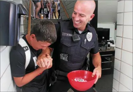  ?? KRISTI GARABRANDT — THE NEWS-HERALD ?? Mike Shaw, school resource officer for Chardon High School and incoming freshman Angelo Ferrante playfully interact during freshman orientatio­n.