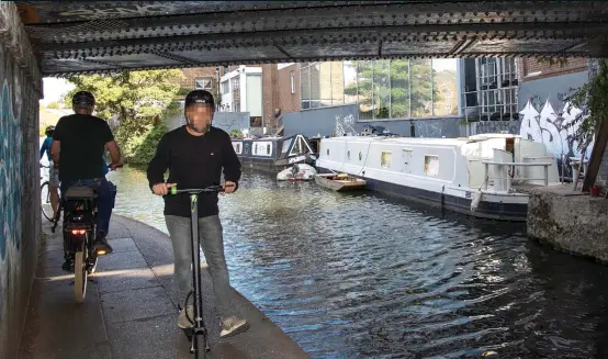  ??  ?? SILENT MENACE: Cyclists and an electric scooter rider vie for space under the bridge beside Regent’s Canal where the young woman was knocked off