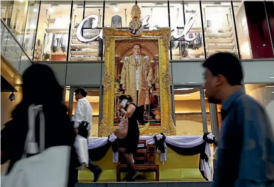  ?? REUTERS ?? A portrait of King Bhumibol Adulyadej is displayed for mourners at a shopping mall in Bangkok. Despite widespread closures, Prime Minister Prayuth Chan-ocha says businesses should remain open.