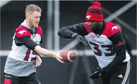  ?? — CP ?? Calgary QB Bo Levi Mitchell, handing off the ball to Jerome Messam during practice on Saturday, says this year’s Stamps are a different group from the one that lost the Grey Cup to Ottawa last year.