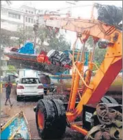  ??  ?? A boat is lifted by a crane off the coast of the Arabian sea in Mumbai; fishermen move to a safer place after cyclone Nisarga made landfall at Uttam in Thane on Wednesday.