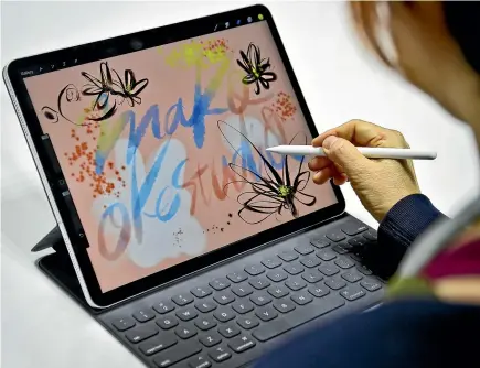  ?? AP ?? An artist draws on the new iPad Pro using its pencil accessory.