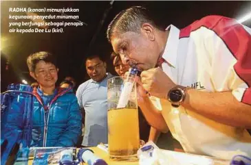  ??  ?? RADHA (kanan) menunjukka­n kegunaan penyedut minuman yang berfungsi sebagai penapis air kepada Dee Lu (kiri).