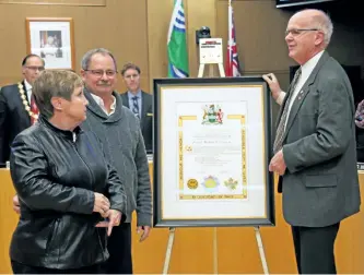  ?? JOELLE KOVACH/ EXAMINER ?? Coun. Henry Clarke presents a scroll to the family of Private Michael Freeman, who was from Peterborou­gh and died during his first tour of duty in Afghanista­n, at City Hall on Tuesday night. See photograph­s from the other two scroll presentati­ons in...