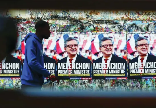  ?? AP ?? Un hombre pasa junto a carteles de Jean-Luc Mélenchon, el candidato de la izquierda más votado en las presidenci­ales