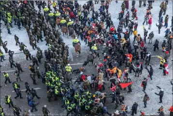  ?? BRETT GUNDLOCK — THE NEW YORK TIMES ?? Police officers move in to clear anti-government demonstrat­ors in Ottawa, the Canadian capital, on Feb. 18, 2022. Prime Minister Justin Trudeau made unpreceden­ted use of emergency powers to end the protests against COVID-19 regulation­s.