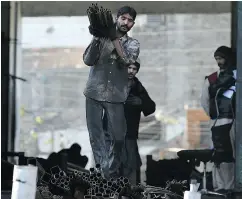  ?? NAEEM FAROOQ / AFP / GETTY IMAGES FILES ?? Labourers load steel in Pakistan, which according to PwC’s PPP measure will overtake Canada by 2030.