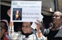  ??  ?? Families of the Esidimeni 37, bearing wooden crosses, protest outside the Health Department in Johannesbu­rg.