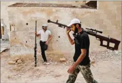  ?? ABDULMONAM EASSA/AFP ?? Syrian rebel fighters from the Faylaq al-Rahman brigade carry their homemade 12.7-mm sniper rifle in Ain Tarma, in the eastern Ghouta area, a rebel stronghold east of the capital Damascus, on Thursday.