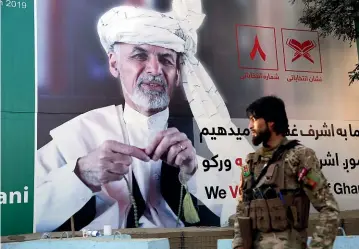  ?? AP ?? An Afghan soldier stands guard in front of a poster for presidenti­al candidate Ashraf Ghani in Kabul. The Taliban is warning Afghanista­n’s 9.6 million eligible voters to stay away from polling stations during today’s presidenti­al election.