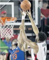  ?? JOHN BAZEMORE/ASSOCIATED PRESS ?? Florida forward Kevarrius Hayes, left, blocks Georgia forward Yante Maten’s shot Tuesday night.