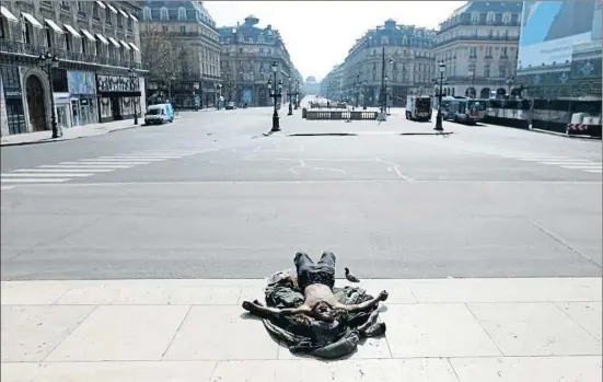  ?? CHARLES PLATIAU / REUTERS ?? Un sintecho ayer frente a la ópera de París, solo frente a la monumental­idad y la pandemia