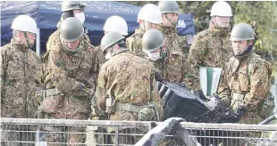  ??  ?? Members of Japan’s Ground Self-Defence Force carry out a piece of wreckage a day after a helicopter crashed in the area in Kanzaki, Saga prefecture. — AFP photo