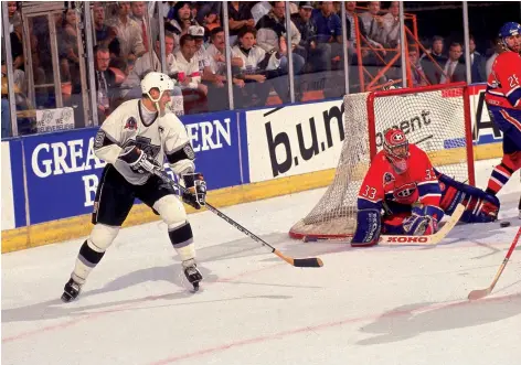  ??  ?? PATRICK ROY ARRÊTE UN TIR DE WAYNE GRETZKY SOUS L’OEIL D’ÉRIC DESJARDINS, AU GREAT WESTERN FORUM, À LOS ANGELES.