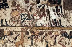  ??  ?? Fresque murale à l'intérieur de la tombe de Huy, vice-roi de Nubie, contempora­ine de Toutânkham­on: scènes de présentati­on du tribut nubien au pharaon.