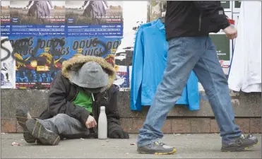  ?? Canadian Press photo ?? A man sits on a sidewalk along East Hastings Street in Vancouver’s Downtown Eastside Thursday.