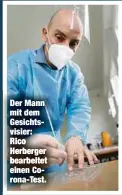  ??  ?? Der Mann mit dem Gesichtsvi­sier: Rico Herberger bearbeitet einen Corona-Test.