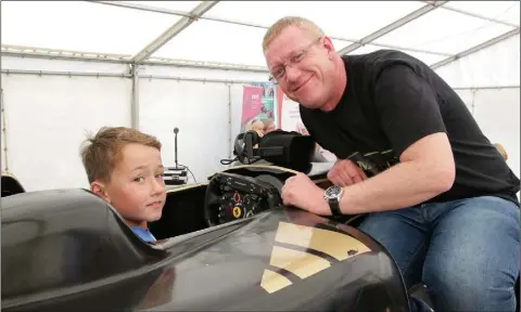  ??  ?? Ian O’Gorman trying out the Formula 1 simulator with instructor Decco Kearney at the Wexford Motor Show on the Quay in Wexford.