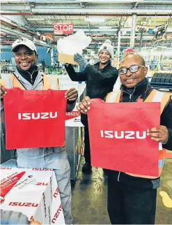  ??  ?? IT’S IN THE BAG: Employees, from left, Sindile Dlabantu, Christophe­r Williams and Henrich Johnson help distribute the reusable Isuzu shopping bags