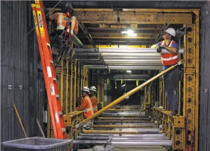  ?? Photos by Paul Chinn / The Chronicle ?? Above: A constructi­on crew works on the new CPMC hospital.