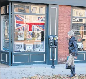  ?? JIM DAY/THE GUARDIAN ?? A woman takes in the window display depicting Charlottet­own and its citizens during wartime. The exhibit, entitled Lest We Forget, is being displayed in the windows of the Planning and Heritage Department at 233 Queen St. until Dec. 1.