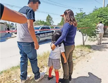  ??  ?? Una menor acompañada de dos adultos, cerca de donde sucedió el doble asesinato en el jardín de niños Luis Donaldo Colosio