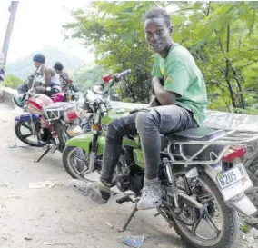  ?? (Photos: Garfield Robinson) ?? Romaine poses on his bike as fellow motorcylis­ts look on at the breakaway on Gordon Town Road in St Andrew on Sunday.