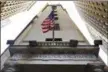  ?? THE ASSOCIATED PRESS FILE ?? The American flag flies above the Wall Street entrance to the New York Stock Exchange.