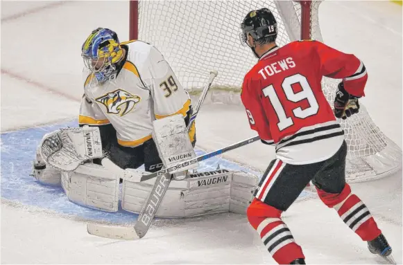  ??  ?? Jonathan Toews ( missing a shot against Predators goalie Marek Mazanec on Nov. 16) has no goals so far. He will be teamed up on a line with Richard Panik and Patrick Kane on Friday. | AP