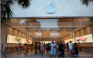  ?? — AFP ?? Customers at an Apple store in Florida. In 2016, Apple stashed more than $200 billion abroad.