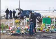  ?? CP PHOTO ?? People visit a memorial at the intersecti­on of a fatal bus crash that killed 16 members of the Humboldt Broncos hockey team last week near Tisdale, Sask. Saturday.