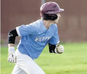  ?? MICHAEL GARD/POST-TRIBUNE ?? Hanover Central’s Gunnar Howes watches the ball as he runs to first during a game against Munster on Friday.