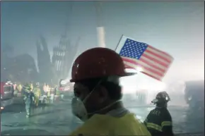  ?? GARY FRIEDMAN/LOS ANGELES TIMES FILE PHOTOGRAPH ?? The facade of one of the towers of the World Trade Center lies in ruins as workmen work in the early morning hours on Sept. 14, 2001.