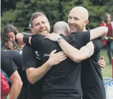  ?? ?? Some of the relay runners embrace after crossing the finishing line.