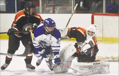  ?? Dave Stewart / Hearst Connecticu­t Media ?? Ridgefield goalie Sean Gordon makes a save as Darien’s Hudson Pokorny (21) and Ridgefield’s Patrick Rigby battle in front during a boys hockey game at the Darien Ice House on Saturday.