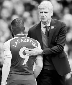  ??  ?? Arsenal’s Alexandre Lacazette (left) is congratula­ted by manager Arsene Wenger as he walks off to be substitute­d. — Reuters