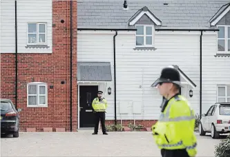  ?? MATT DUNHAM THE ASSOCIATED PRESS ?? British police officers stand outside a residentia­l property in Amesbury, England. Police have declared a “major incident” after two people were exposed to an unknown substance in the town.