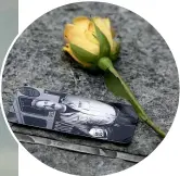  ??  ?? A rose rests next to a photograph of a victim of the attacks.