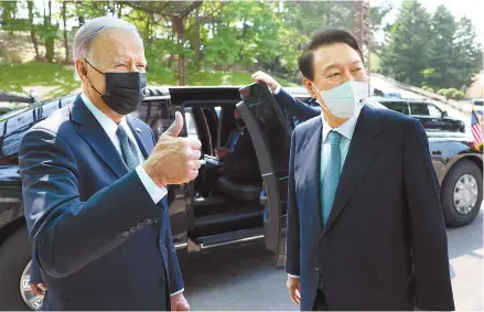  ?? Yonhap ?? U.S. President Joe Biden gives a thumbs up as he wraps up his three-day visit to Korea at Osan Air Base in Gyeonggi Province, Sunday. President Yoon Suk-yeol stands next to Biden who is headed for Japan.