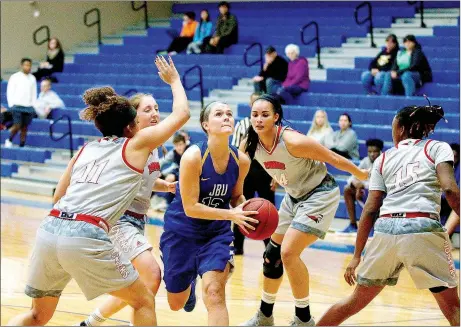  ?? Photo courtesy of JBU Sports Informatio­n ?? John Brown sophomore guard Jordan Martin drives through four MidAmerica Nazarene (Kan.) defenders during Saturday’s game at Bill George Arena. The Pioneers defeated the Golden Eagles, 58-49.