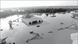  ?? Associated Press ?? A business is surrounded by floodwater­s Saturday near the Brazos River in Sugar Land, Texas.